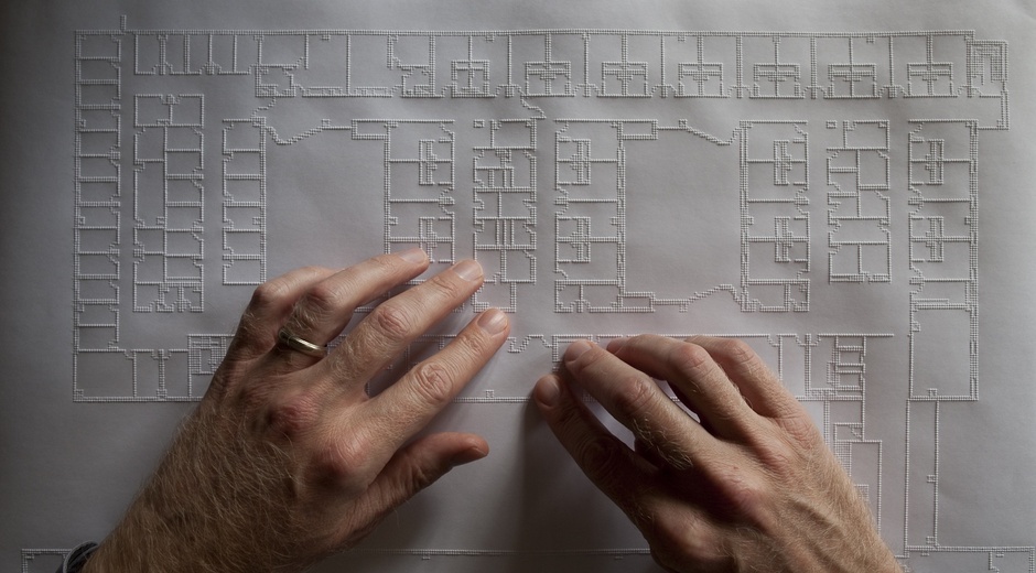 Downey reads a plan of the Blind Rehabilitation Center at the VA campus in Palo Alto, California. (Fogg Studio).