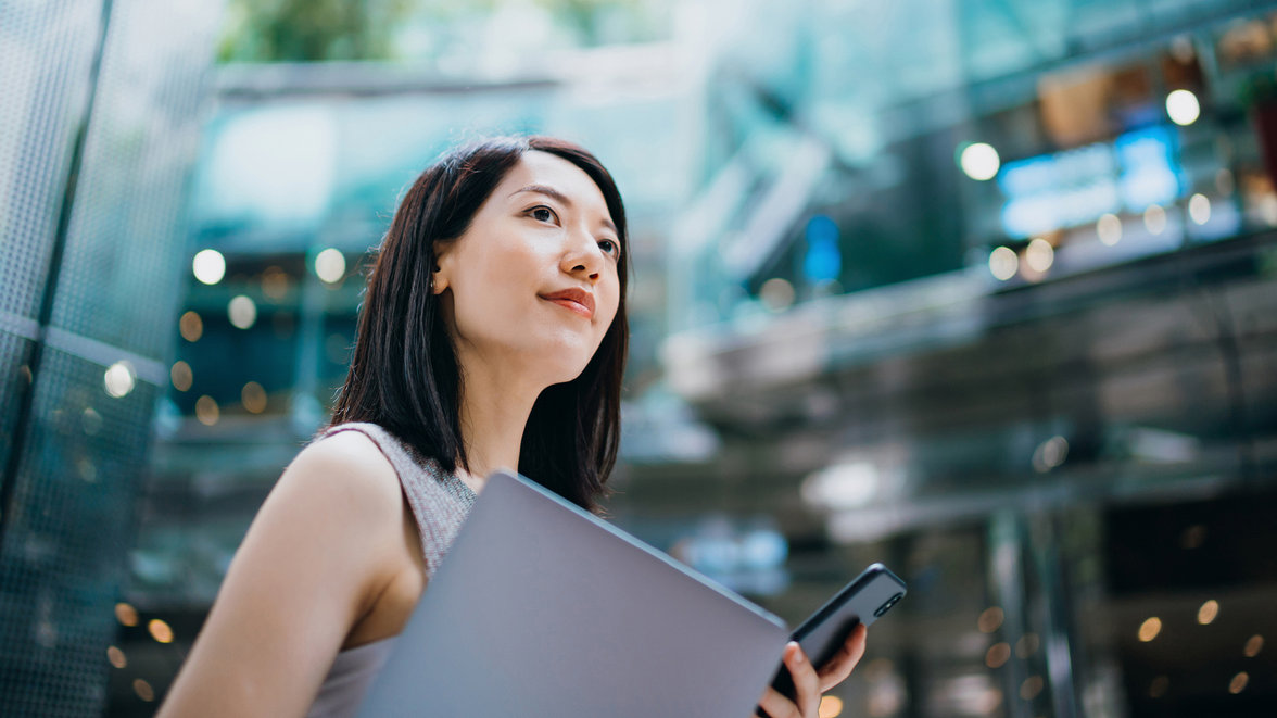 Female holding a laptop and mobile phone