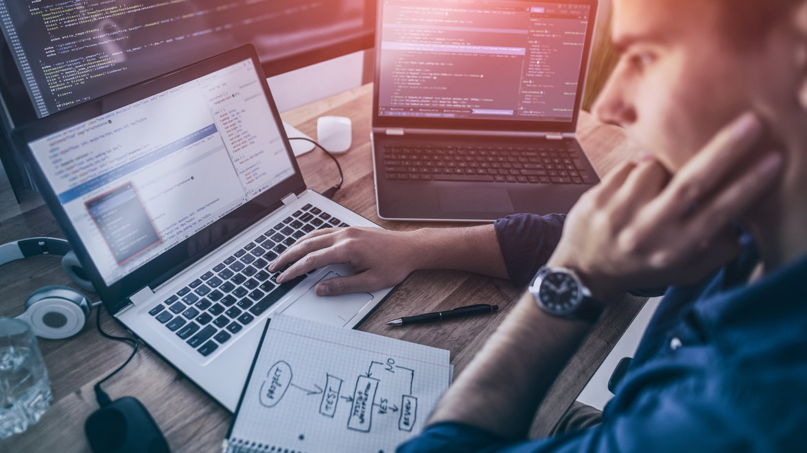 Person using laptop with flowchart design on notebook